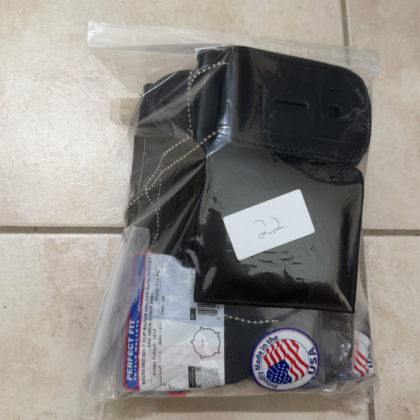 Black leather phone-wallet case sealed in a clear plastic bag, with a small white label and a 'Made in USA' sticker visible.